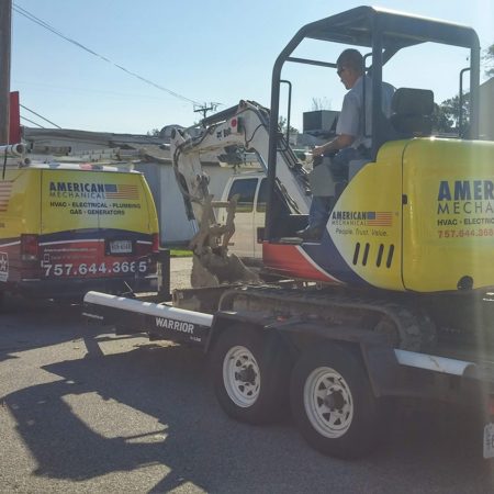 American Mechanical crane on a flatbed truck behind an American Mechanical utility van