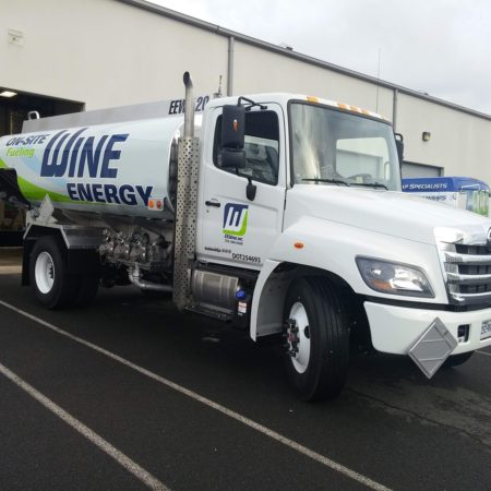 Wine Energy gasoline truck parked outside of an industrial garage