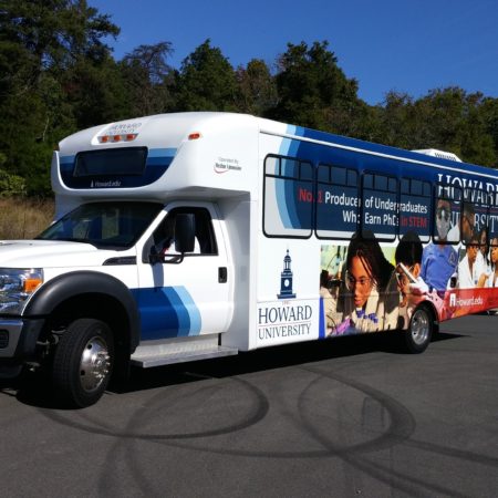 Bus parked on a side street with vehicle wrapping for Howard University