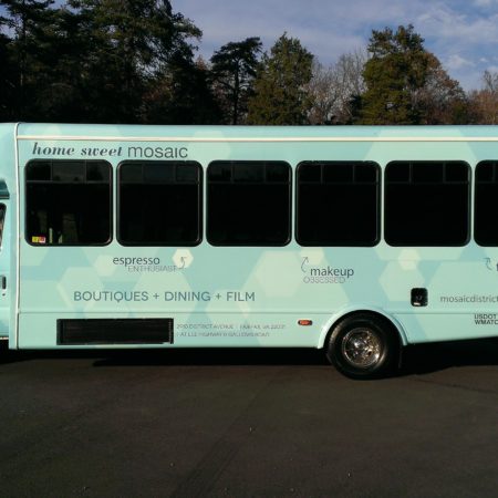 Bus parked on a side street near the forest with vehicle wrapping for the Mosaic District