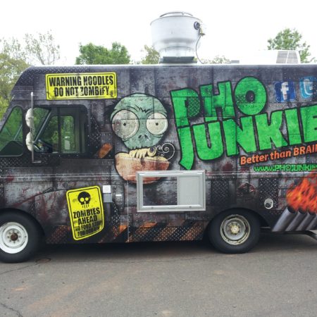 Pho Junkies food truck parked on the side of the road next to a forest